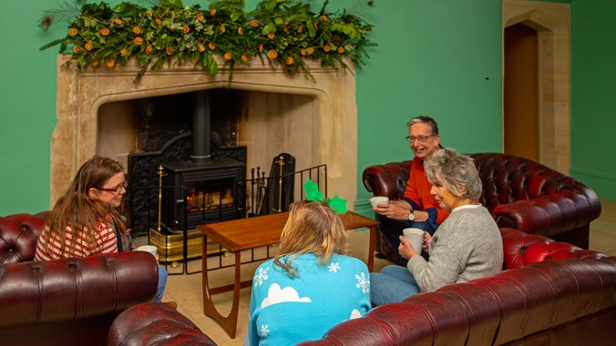 Visitors to Lyveden enjoy festive treats by the fire in the decorated cafe.